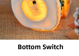 Macro view of the resin Christmas house base featuring the integrated power toggle switch