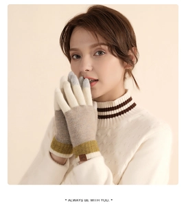Close-up of tricolor knitted wool gloves with ribbed cuffs and decorative square label