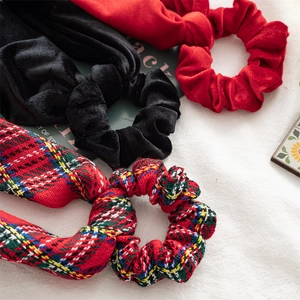 Detail of Christmas velvet scrunchies with ribbons in black, red and classic plaid patterns