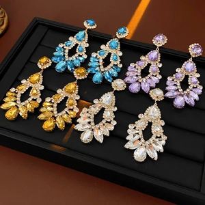 Macro detail of teardrop tassel earrings with sparkling rhinestones in four vibrant colors