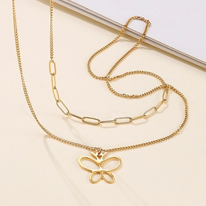 Double-layer gold butterfly pendant necklace with paperclip chain on beige background