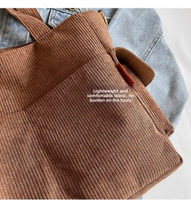 Detail of caramel corduroy tote bag featuring vertical texture and logo label