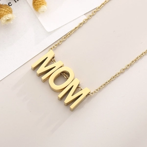 Gros plan d'un collier doré avec pendentif MOM poli et chaîne fine élégante