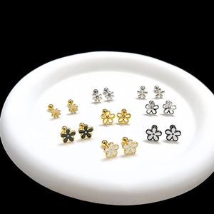 Detail view of gold flower stud earring sets with enamel finish and screw ball backs