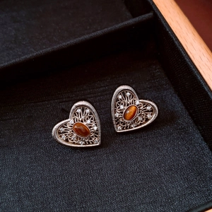 Detail of vintage heart stud earrings with brown tiger eye stone and zircon in silver