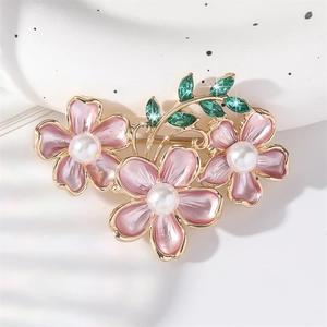 Elegant floral brooch featuring pink enamel flowers and pearls on gold stems