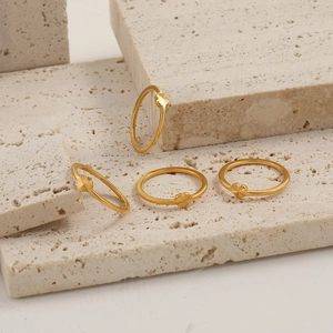 Set of four gold heart rings with sunburst texture on minimalist thin metal bands