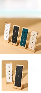 Detail view of multi-slot wooden necklace display stand with plush padded backboards