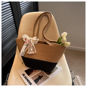 Detail of woven tote bag with bicolor contrast and floral lace bow decoration
