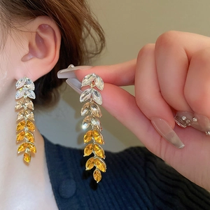 Detail of gradient crystal wheat leaf tassel earrings showing yellow marquise cut stones