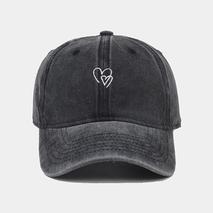 Detailed close-up of the vintage washed grey baseball cap with white heart embroidery