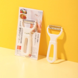 Close-up of Japanese dual-blade vegetable peeler with stainless steel blades and packaging