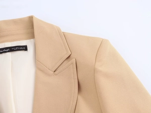 Detail of peak lapel and shoulder tailoring on a khaki slim fit blazer with brand tag
