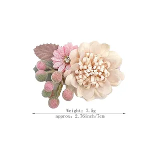Handmade artificial flower hair clip with pink fabric petals and bright rhinestone center