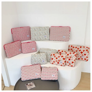 Quilted laptop sleeves with floral and heart prints on a white minimalist display stand