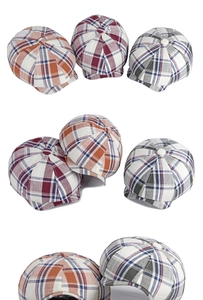 Detail view of plaid newsboy hats in orange, burgundy, and gray blue wool fabric