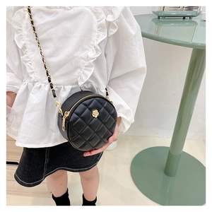 Detailed shot of a quilted round mini bag for children with a gold flower metal buckle