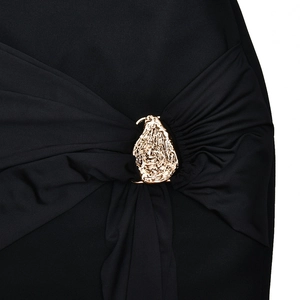 Detail of waist pleats and gold irregular metal buckle on a black bodycon dress