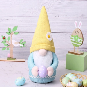 Close-up of Easter gnome doll holding a purple polka dot egg with yellow knit hat