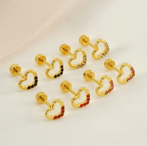 Macro detail of gold heart earrings set with colorful rhinestones in an elegant layout