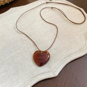 Collana vintage con pendente a cuore in resina ambrata e cordino marrone regolabile