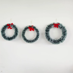 Three sizes of green Christmas wreaths with red bows hanging against a white background