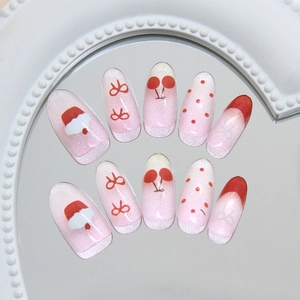 Pink cat eye press-on nails with cute hand-painted cherry and bow Christmas designs