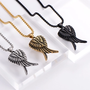 Détail des pendentifs en forme d'ailes d'ange en finitions argent, or et noir sur chaînes