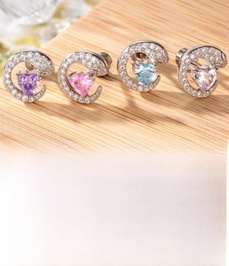 Detail of silver heart-shaped zircon ear studs with screw backs in four colors