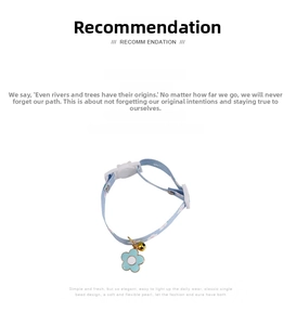 Detail of light blue floral pet collar with enamel flower pendant and golden bell