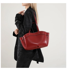Dettaglio della borsa tote in pelle rossa con bordo ondulato e tasche laterali