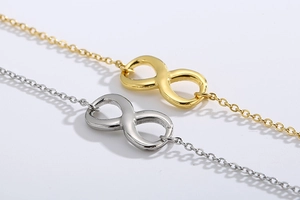 Close-up of titanium steel infinity symbol bracelets in gold and silver finishes