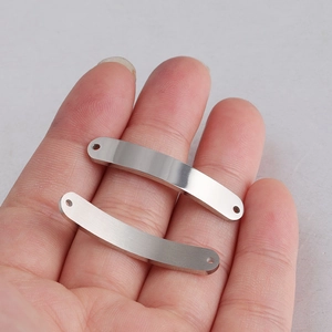 Macro shot of curved stainless steel rectangle connectors with holes on a palm