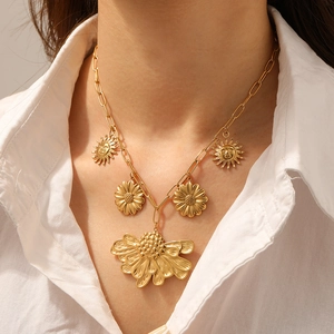 Gold plated vintage sunflower and sun pendant necklace with paperclip chain on a model