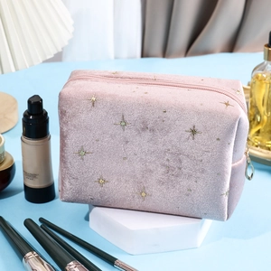 Detail of pink velvet makeup bag with gold and silver star embroidery and metal zipper