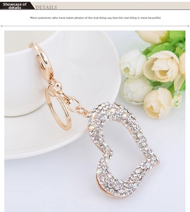 Detailed view of hollow heart keychain with crystals hanging on a white coffee cup
