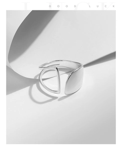 Detailed view of irregular hollow silver ring with polished surface and open geometric frame