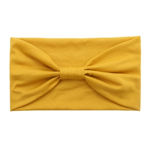 Detail view of the yellow knotted cotton headband with elastic knit fabric texture