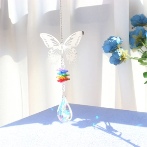 Detail of silver butterfly crystal suncatcher with teardrop prism creating rainbow spots