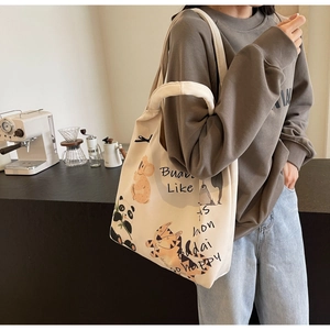 Detail view of animal illustration print on off-white canvas tote bag with text