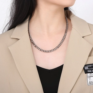 Close-up of a silver Cuban link necklace worn by a model for a trendy street style look