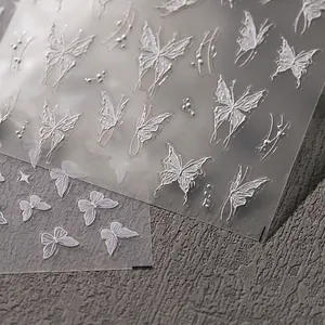 3D white butterfly relief nail art stickers with embossed textures on dark stone background