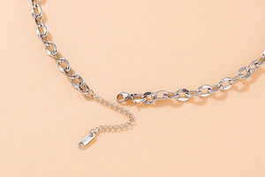 Close-up of stainless steel necklace lobster clasp and S.STEEL engraved tag on silver chain