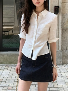 Détail du chemisier en lin blanc à manches mi-longues et boutons sur le mannequin