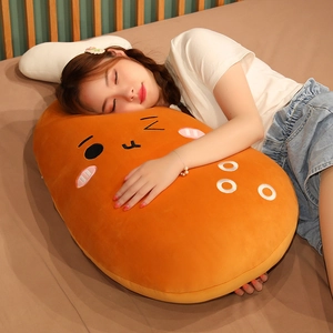 Close-up of a large cartoon chicken leg plush pillow with soft orange fabric and smiling face