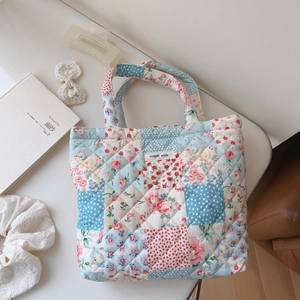 Detailed view of quilted cotton handbag with floral patchwork and simple wish label