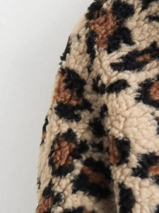 Gros plan sur la texture en fausse fourrure léopard d'un tissu de veste d'hiver