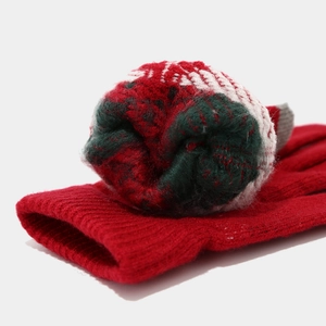 Detailansicht der roten Strickhandschuhe mit weicher Textur und festlichen Farbakzenten