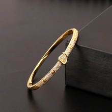 Dettaglio bracciale leopardo placcato oro con zirconi su scatola di pelle nera di lusso