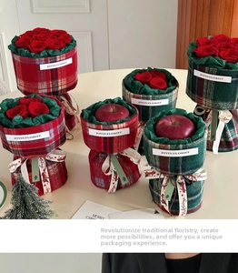 Detail of Christmas plaid fabric bouquet wrap with red rose and apple festive decor